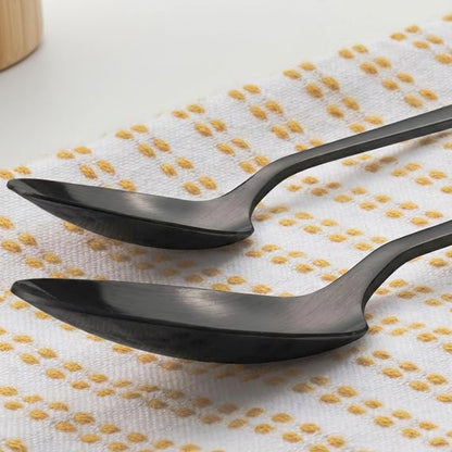 Overhead view of the 16-piece Salter Chiltern cutlery set in brushed matte black stainless steel arranged neatly on a dark slate dining table.