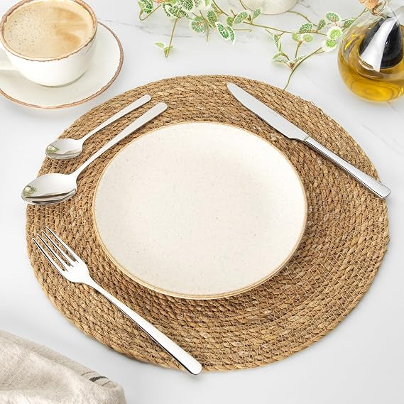 Salter Harrogate Kendal 16 piece mirror polished 18/10 stainless steel cutlery set neatly arranged on a wooden dining table.