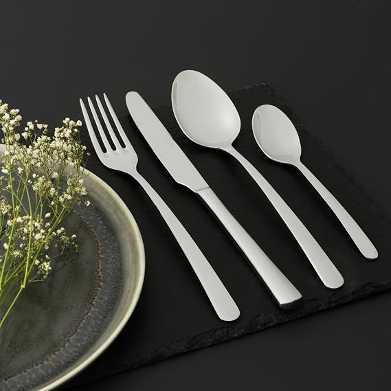Salter Kendal 32 piece mirror polished silver cutlery set arranged neatly on a wooden dining table including forks knives tablespoons and teaspoons.