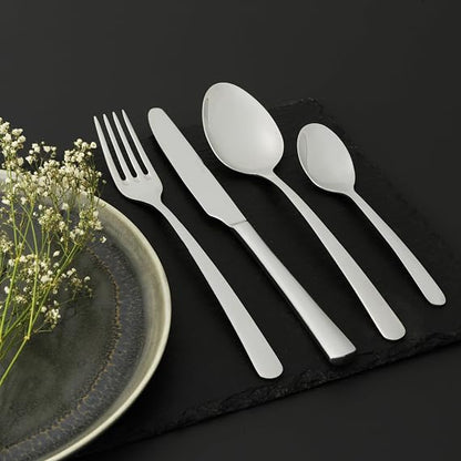 Salter Kendal 32 piece mirror polished silver cutlery set arranged neatly on a wooden dining table including forks knives tablespoons and teaspoons.