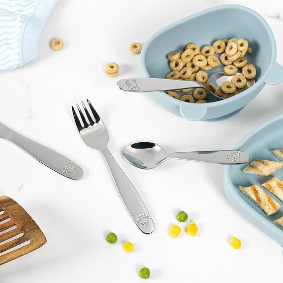 Salter 12-piece stainless steel kids cutlery set with farmyard animal engravings laid out on a clean light table setting.