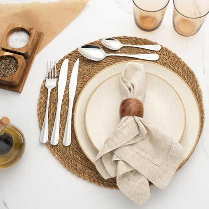 Top-down view of the 24-piece silver Salter Newbury stainless steel cutlery set with mirror finish arranged neatly on a dark wooden dining table.