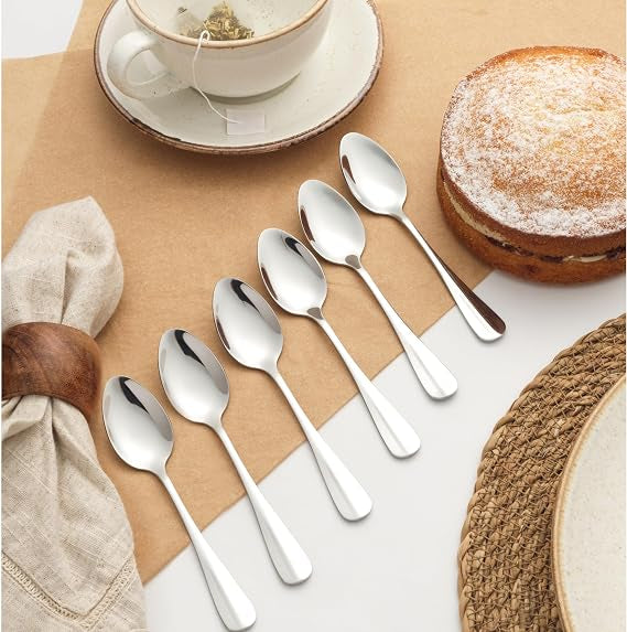 Six silver Salter Newbury polished stainless steel teaspoons neatly arranged side by side on a light wooden tabletop.