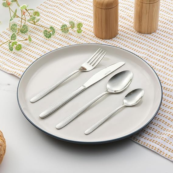 Salter Prestbury 16 piece silver stainless steel cutlery set arranged on a modern dining table showcasing a polished mirror finish.