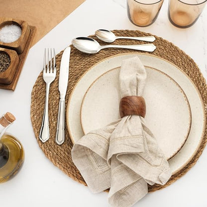 Salter Richmond 24 piece silver stainless steel cutlery set neatly arranged on a dark wooden dining table showcasing polished knives, forks, and spoons.