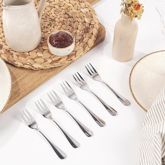 Silver Salter Soho 16-piece 430 stainless steel cutlery set arranged neatly for four place settings on a wooden dining table.