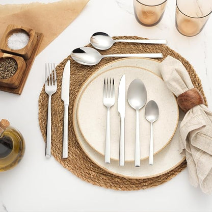 Silver Salter Winslow 44-piece polished stainless steel cutlery set arranged neatly on a dark wooden dining table setting.