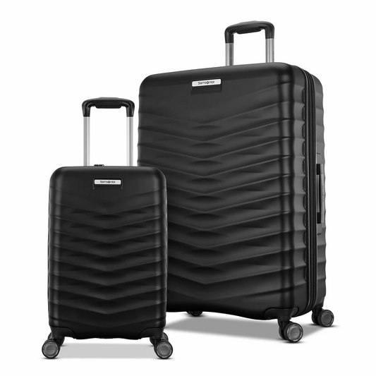 Front angle view of two Samsonite Precision DLX hardside spinner luggage pieces in slate grey standing upright on a sleek terminal floor.