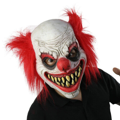 Front view of a detailed scary joker latex clown mask with red accents and realistic face contours against a plain background.