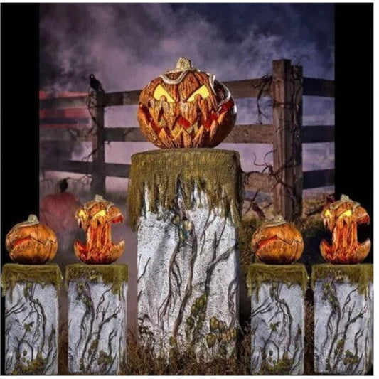 Front angle shot of a 20cm orange scary pumpkin animatronic prop with carved jagged teeth and glowing red LED eyes on a dark table.