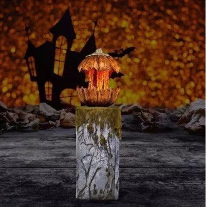 Front angle shot of a 20cm orange scary pumpkin animatronic prop with carved jagged teeth and glowing red LED eyes on a dark table.