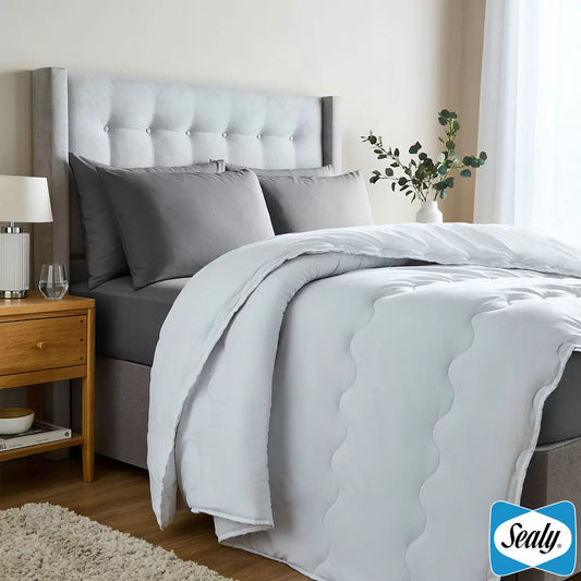 White Sealy Deeply Full single duvet with silky microfibre texture folded neatly at the foot of a bed.