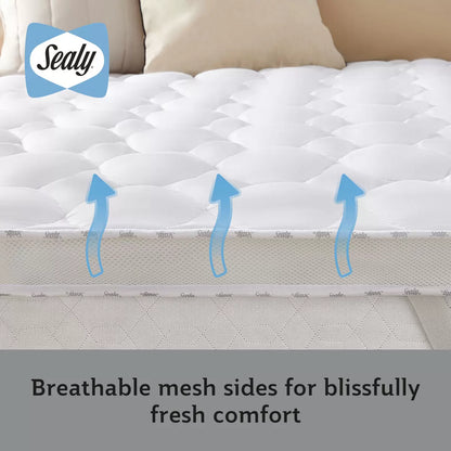Close-up view of the white Sealy Deeply Full Mattress Topper showing corner elastic straps and stitched microfibre detail on a dressed bed.