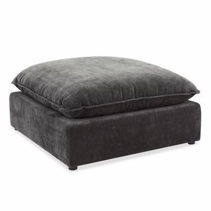 Angled studio shot of the square Sereen dark grey fabric ottoman, showcasing its thick, plush feather-blend cushion top and solid profile on a neutral background.