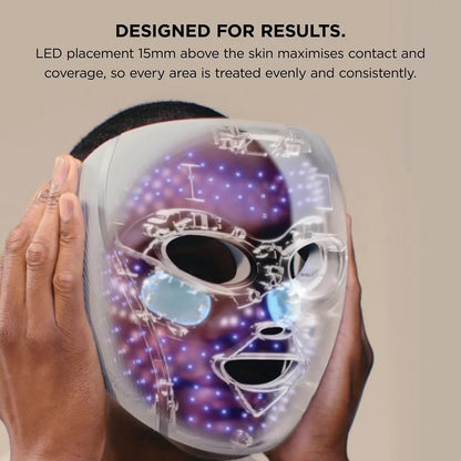 Shark CryoGlow LED therapy mask in Lilac Chill with silicone eye guards, attached handheld controller, and USB-C cable displayed on a white marble vanity.