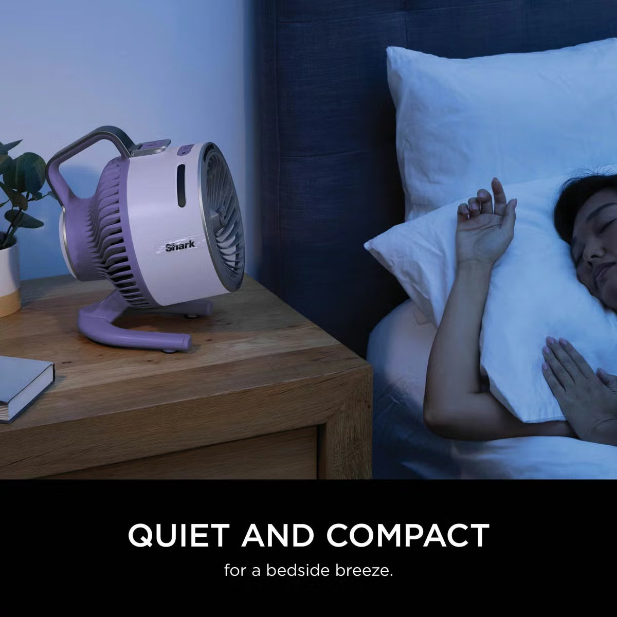 Front three-quarter view of the compact lilac Shark FlexBreeze HydroGo misting fan sitting on a garden table blowing a fine cooling mist.
