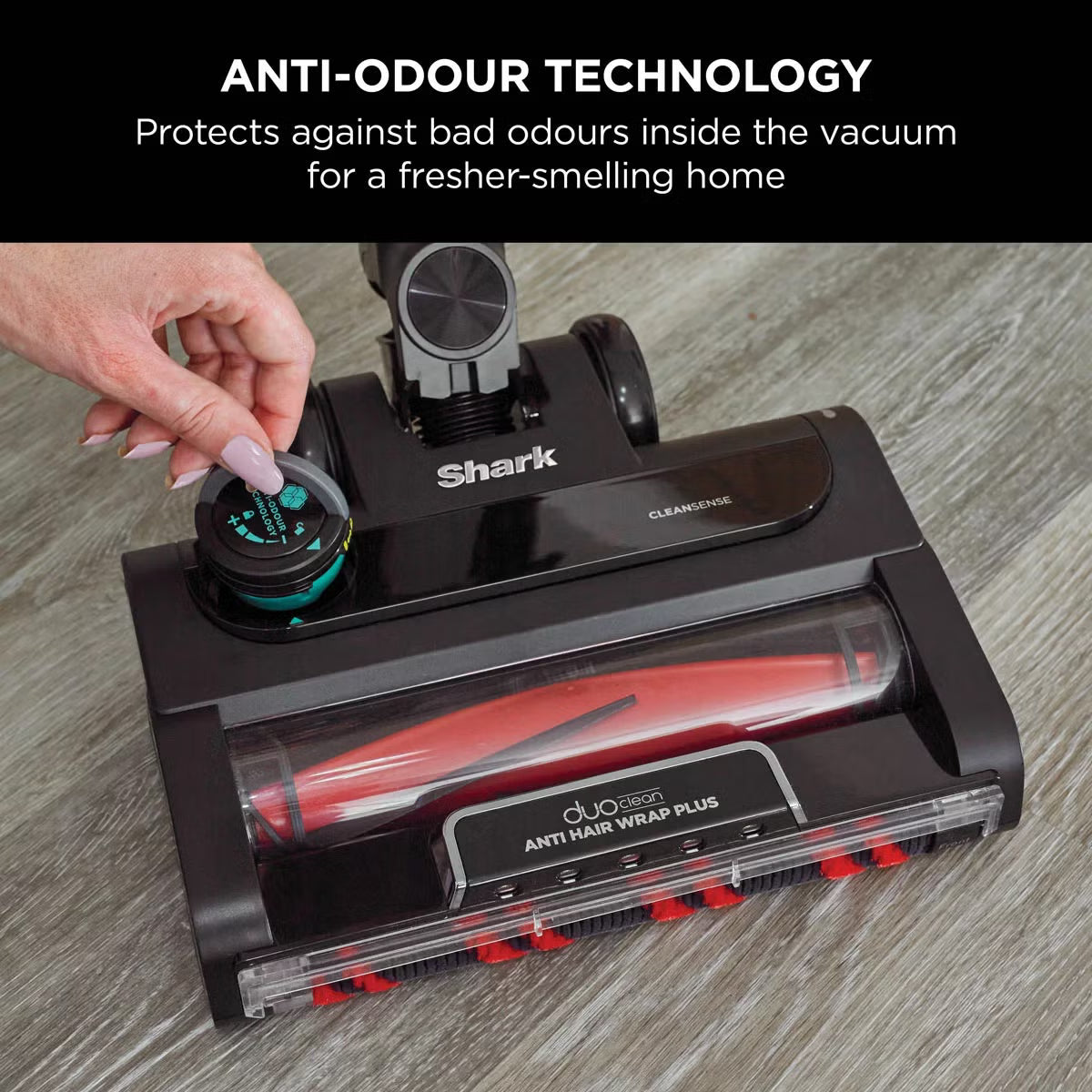 Front angle view of the charcoal grey and copper Shark IZ400UKT Stratos cordless vacuum standing on a wooden floor alongside pet accessories.