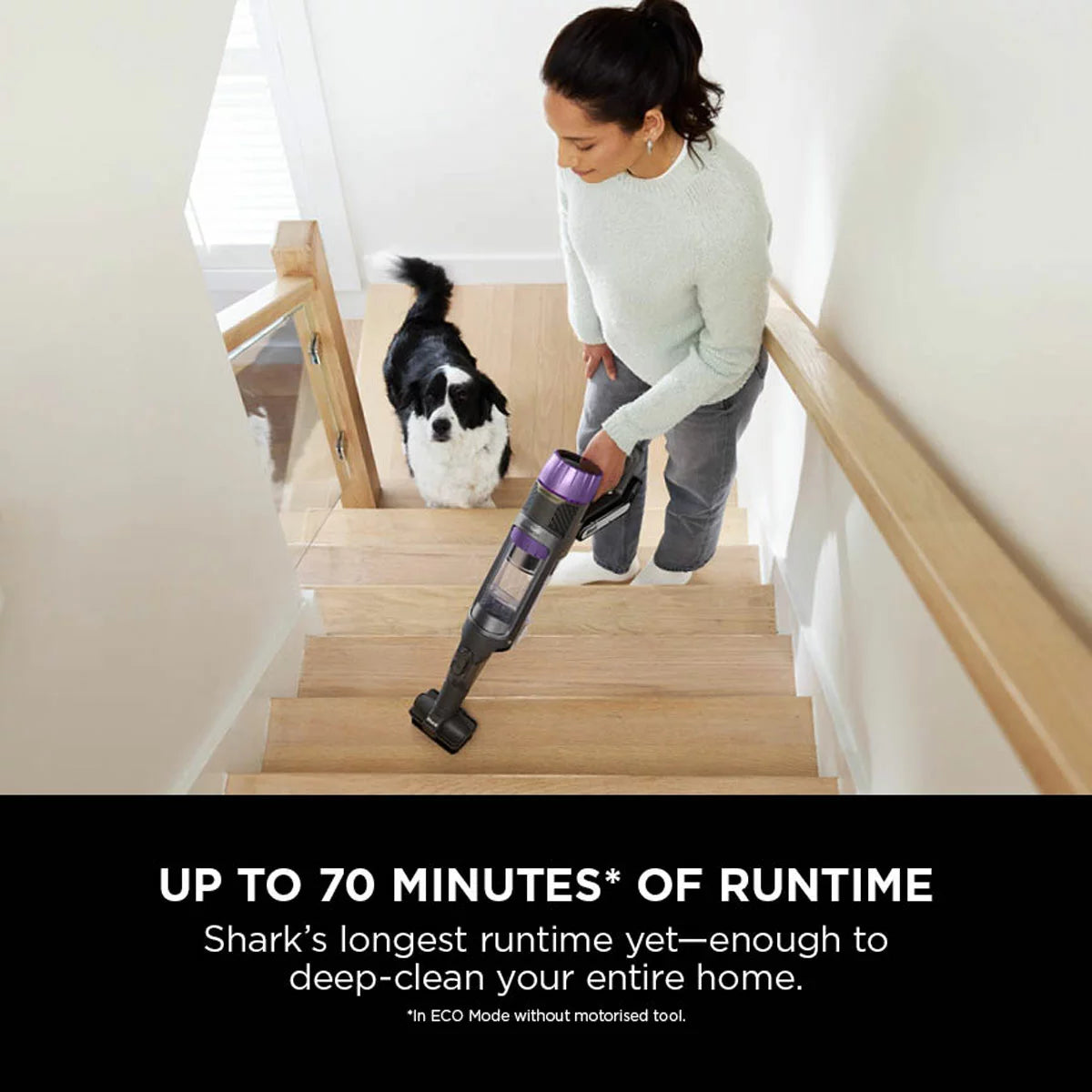 Front view of the dark teal Shark PowerDetect IP3251UKT cordless vacuum cleaner docked on its upright auto-empty charging base in a modern living room setting.