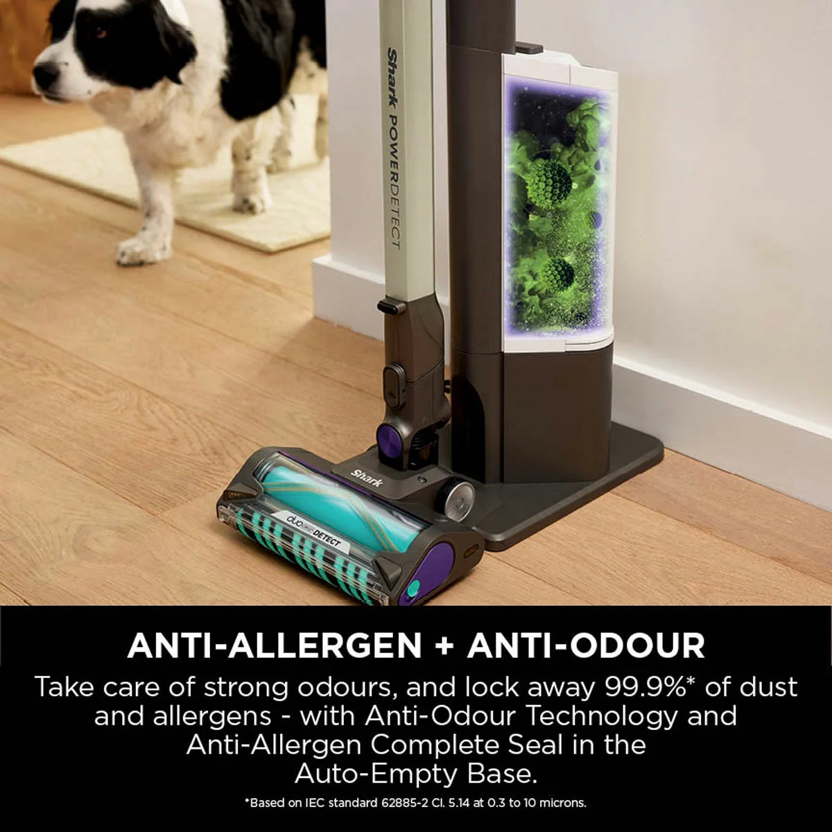 Front view of the dark teal Shark PowerDetect IP3251UKT cordless vacuum cleaner docked on its upright auto-empty charging base in a modern living room setting.