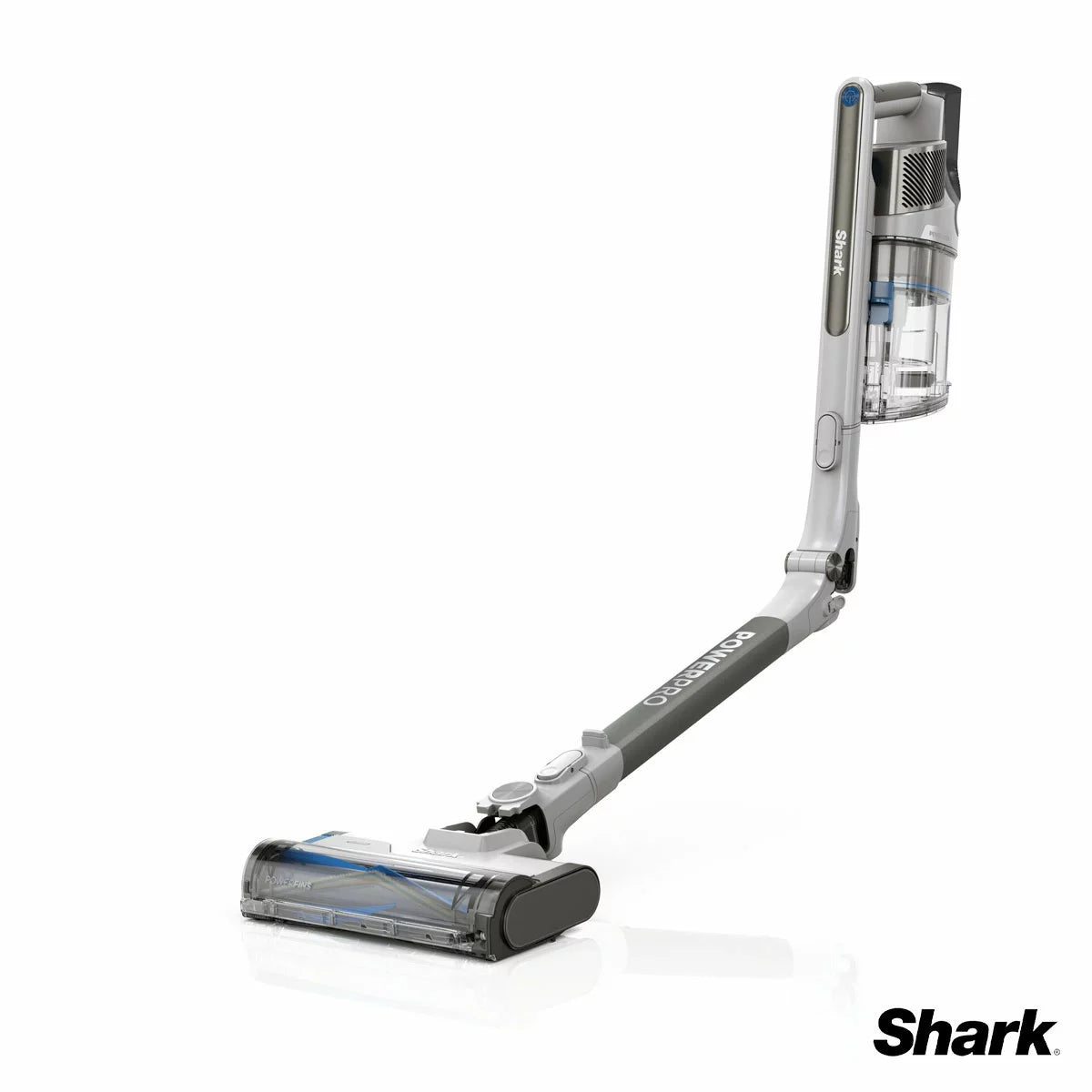 Front angle view of the dark grey Shark PowerPro Pet Cordless Vacuum standing upright on a light wooden floor beside a rug with pet hair accessories attached.