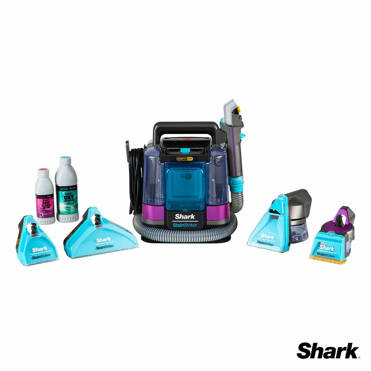 Front view of the white and deep navy Shark StainStriker HairPro PX250UKT spot cleaner sitting on a beige living room rug beside its attached hose and pet hair extraction tool.