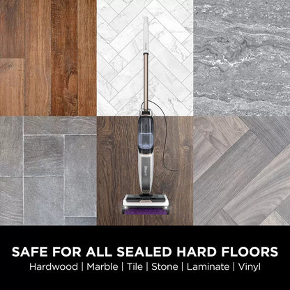 Front view of the dark grey Shark SteamPickUp SD200UK hard floor cleaner standing upright on its storage dock over light wood laminate flooring.