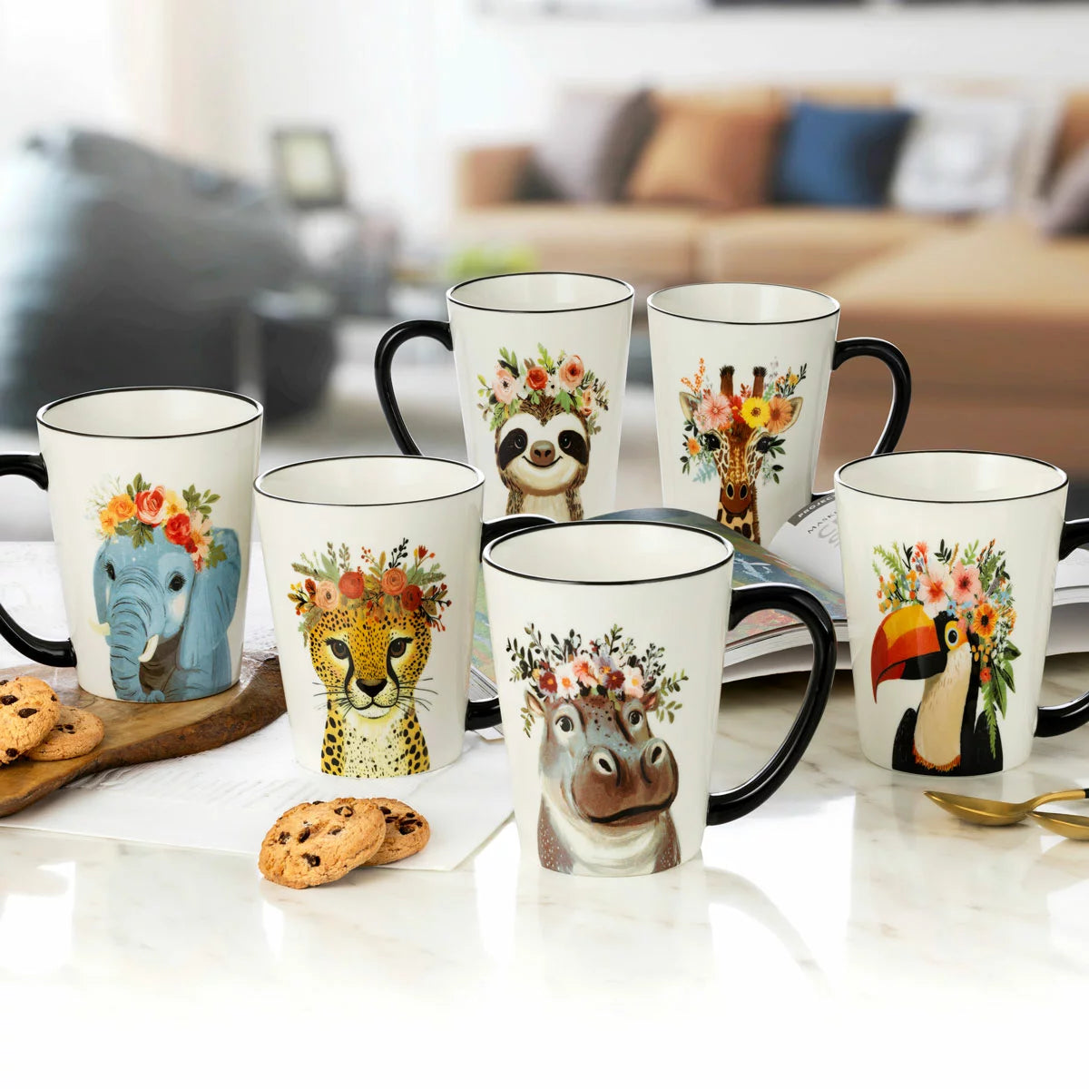 A set of six Signature Housewares 483ml stoneware mugs featuring colourful illustrations of a toucan, giraffe, hippo, elephant, cheetah, and sloth wearing hipster accessories, displayed on a clean kitchen counte