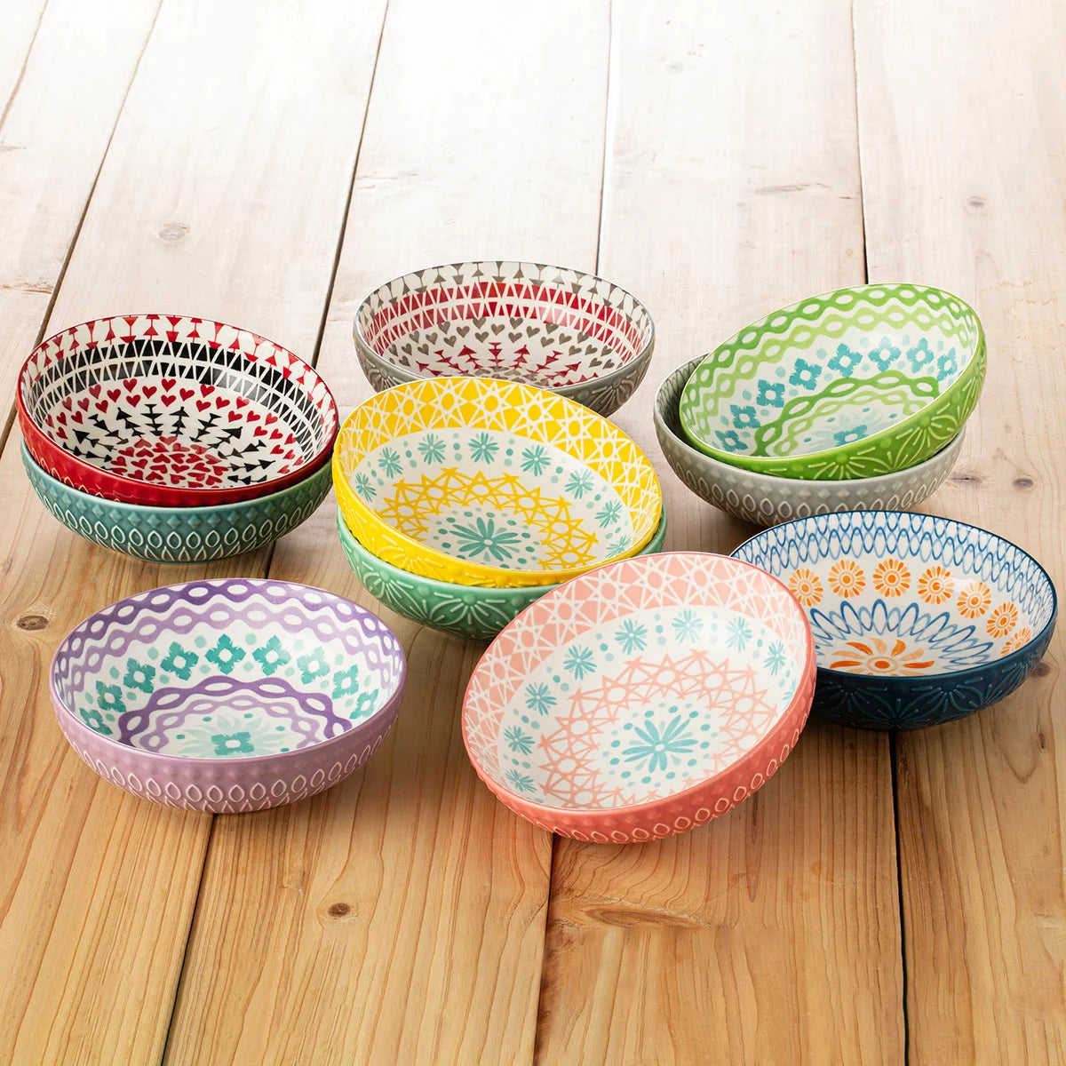 The Signature Housewares Stoneware Bowls 10-Piece Set arranged together, showcasing their vertical stripe patterns and array of ten distinct, vibrant colors.