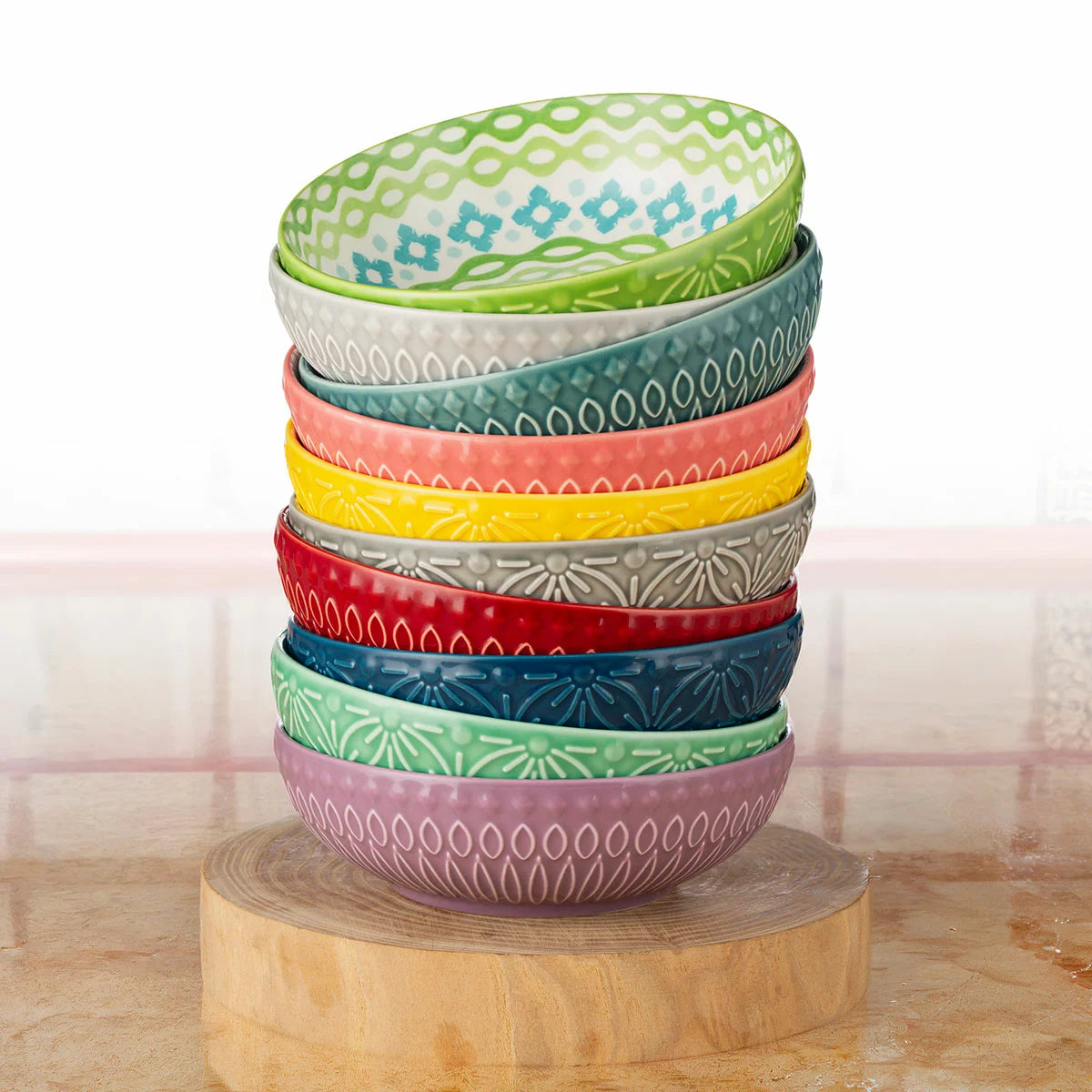The Signature Housewares Stoneware Bowls 10-Piece Set arranged together, showcasing their vertical stripe patterns and array of ten distinct, vibrant colors.