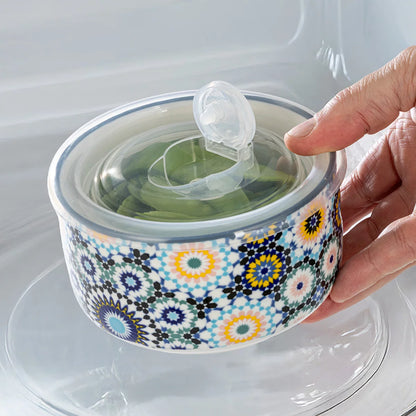 The Signature Stoneware Bowls with Lids 6-Pack displayed on a table, showcasing their colorful patterned exteriors and matching storage lids.