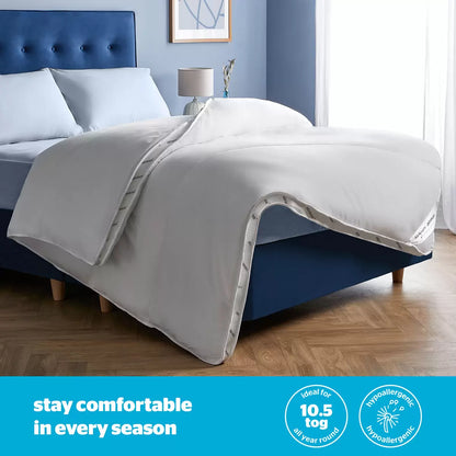Crisp white Silentnight Airmax 10.5 Tog duvet and two matching pillows with blue mesh side borders arranged neatly on a freshly dressed bed.