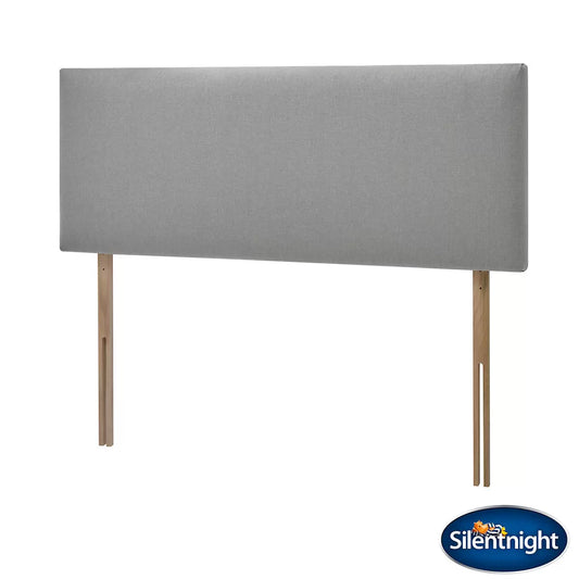 Front view of a Silentnight Bexley Grey Fabric Headboard with modern padded vertical stitching mounted on a bed frame against a light bedroom wall.