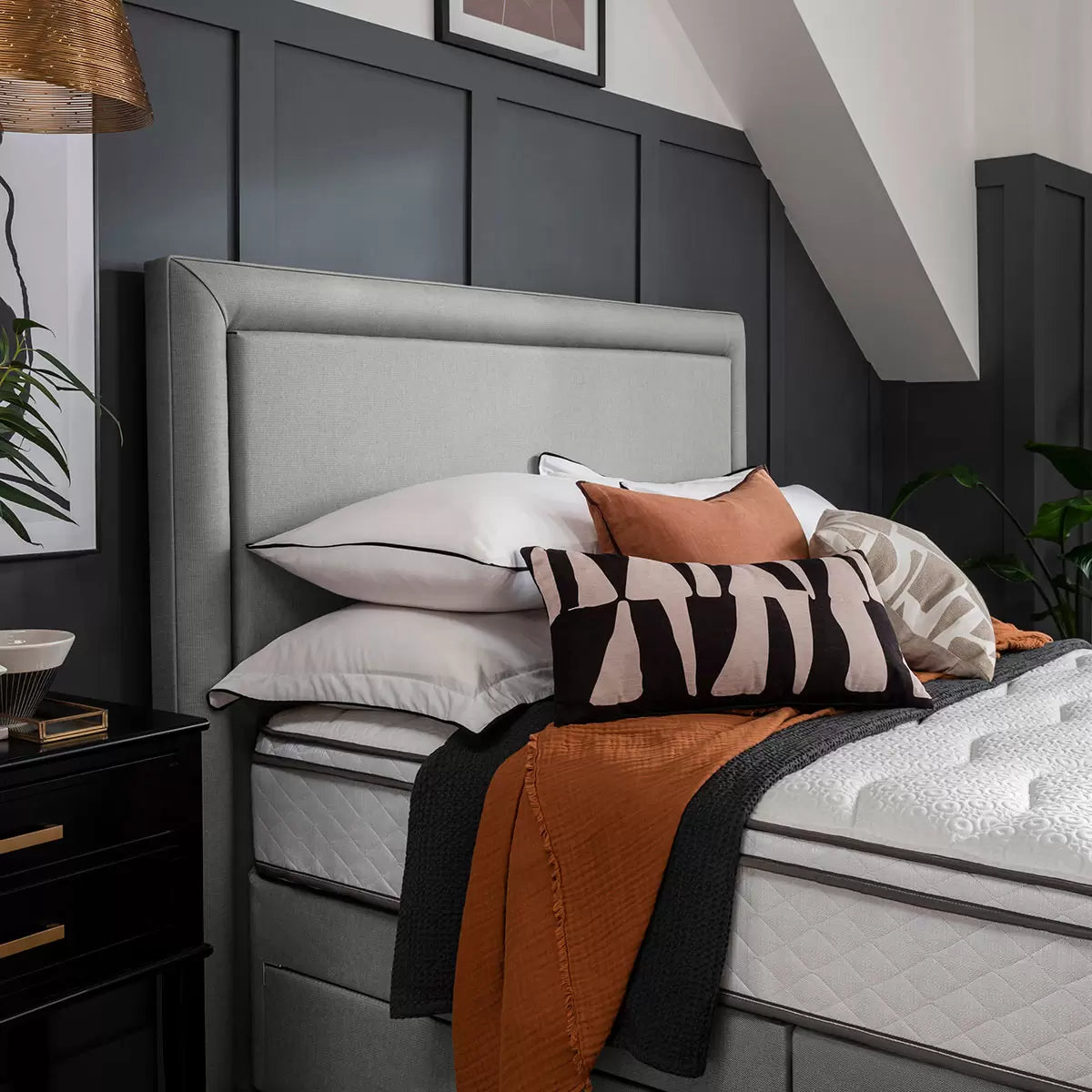 Front view of the slate grey Silentnight Palermo full height fabric headboard with a minimalist bordered frame installed behind a neatly made bed in a contemporary modern bedroom setting.