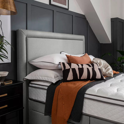 Front view of the slate grey Silentnight Palermo full height fabric headboard with a minimalist bordered frame installed behind a neatly made bed in a contemporary modern bedroom setting.