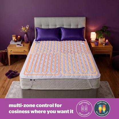 Close-up angled shot of the white Silentnight Deep Sleep Superking Heated Quilted Topper fitted over a mattress with its dual hand controller visible on a bedside table.
