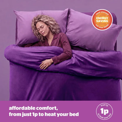 Close-up angled shot of the white Silentnight Deep Sleep Superking Heated Quilted Topper fitted over a mattress with its dual hand controller visible on a bedside table.