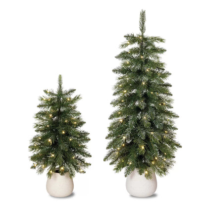 Pair of 2ft and 3ft silver glitter potted artificial trees with glowing warm white twinkling LED lights sitting on a white porch threshold.
