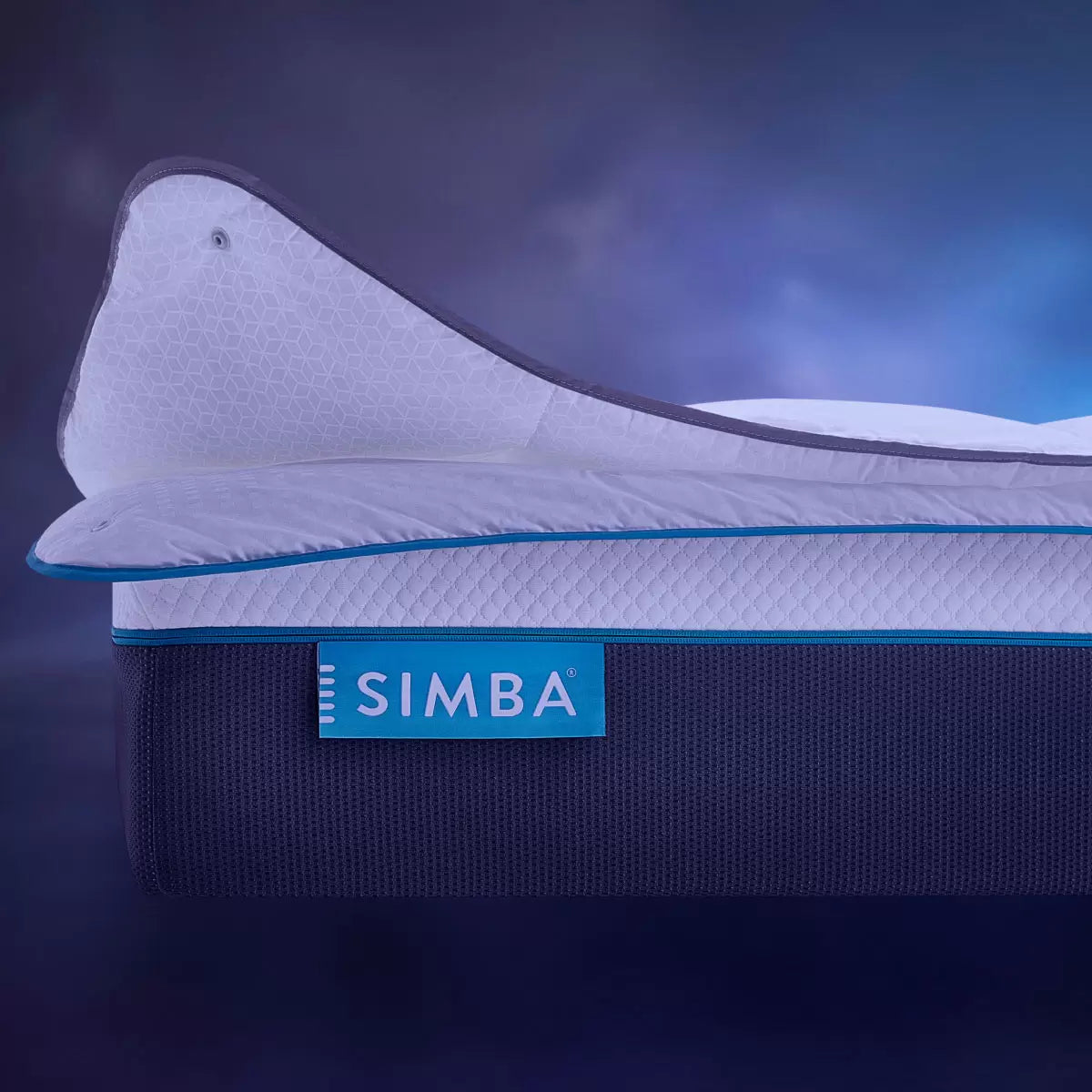 Angle view of the white Simba Hybrid 3-in-1 duvet showing its square-stitched baffle design and snap fasteners dressed neatly on a king-size bed in a sunlit bedroom.