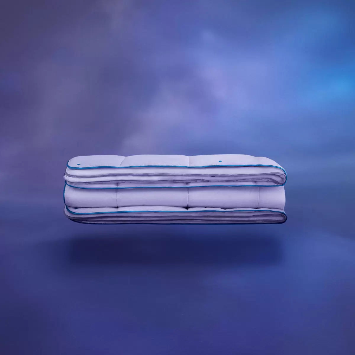 Angle view of the white Simba Hybrid 3-in-1 duvet showing its square-stitched baffle design and snap fasteners dressed neatly on a king-size bed in a sunlit bedroom.