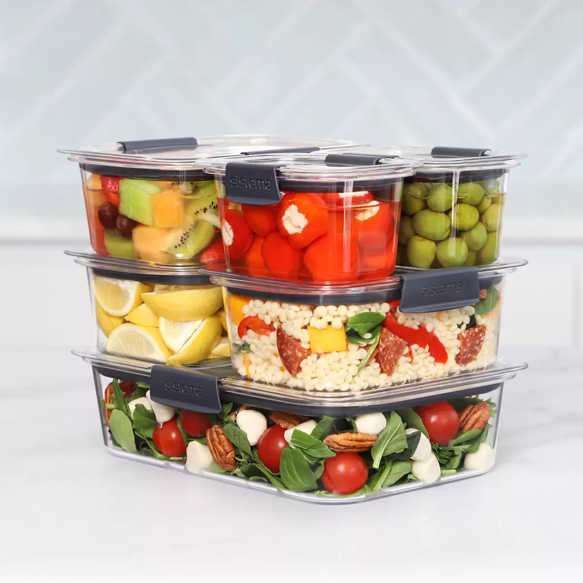 A 14-piece Sistema Brilliance food storage set organized neatly on a kitchen counter, showcasing clear containers and grey leak-proof lids.