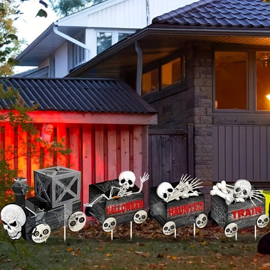 Side angle view of four plastic Halloween skeleton train garden stakes pushed securely into a green grass lawn.