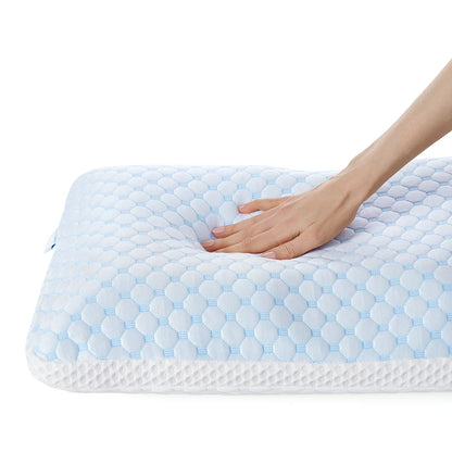 White rectangular dual-sided cooling memory foam pillow displaying textured ventilation pattern on a modern bed setup.