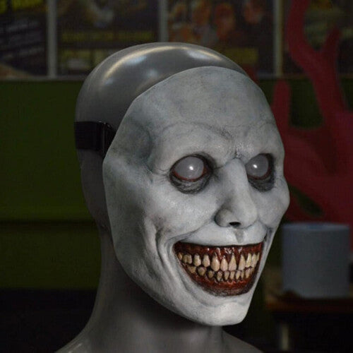 Front view of a creepy ashen gray smiling demon latex mask featuring oversized eyes and a wide gaping mouth.