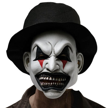 Front view of a creepy half-face smiling evil clown mask featuring painted details, attached dark synthetic hair, and an elastic strap on a clean backdrop.