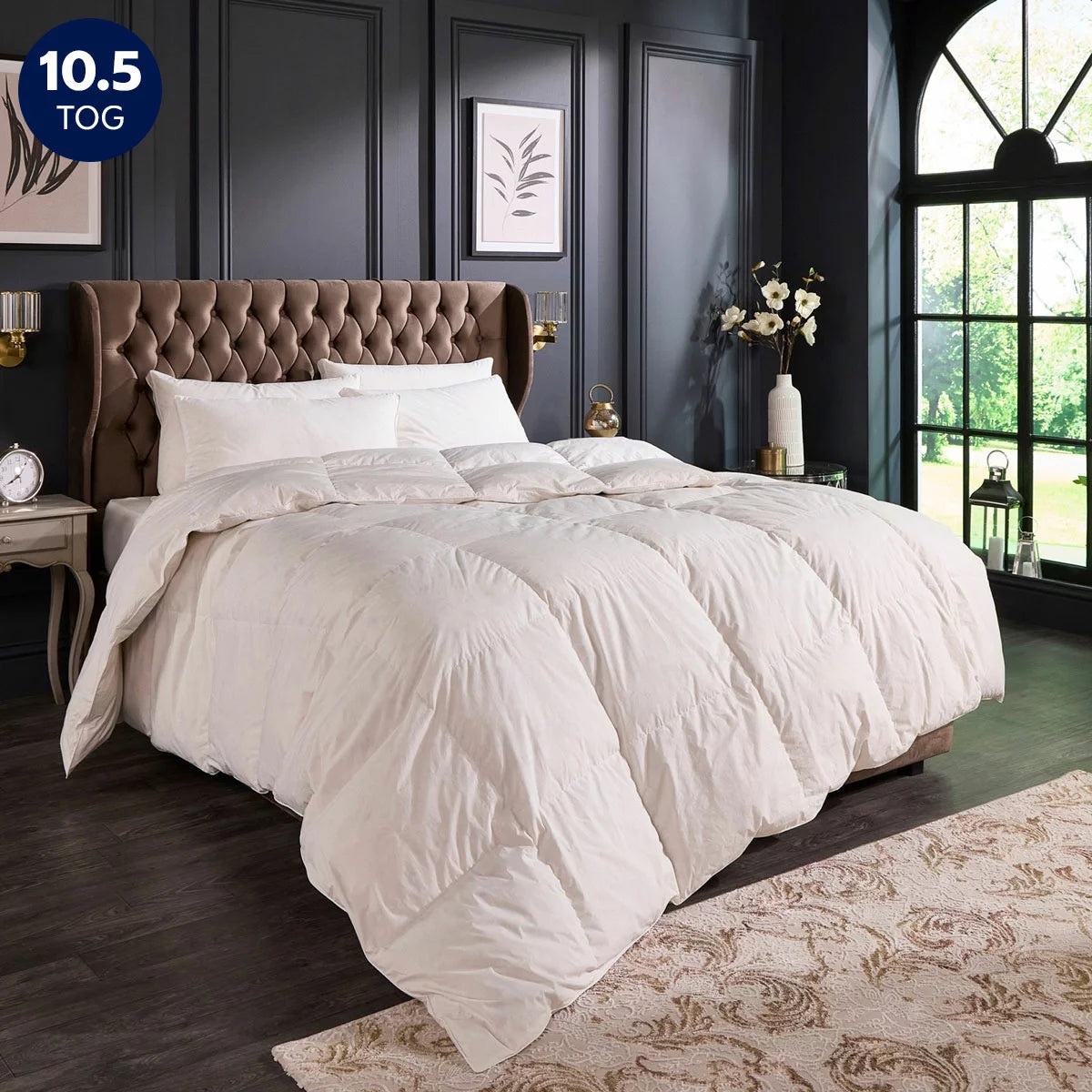 Angle view of the white Snuggledown Retreat Hungarian Goose Down 10.5 Tog duvet dressed on a king-size bed, highlighting its 300 thread count cotton jacquard weave and double-stitched piped edges.