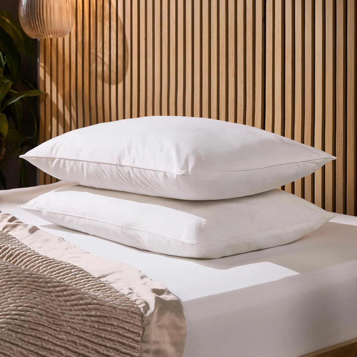 Pair of white Snuggledown Soft As Down pillows with elegant piped edges styled on a crisp hotel-style bed.