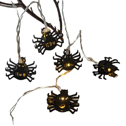 Creative spider LED string lights glowing with a spooky ambiance along an outdoor patio wall.