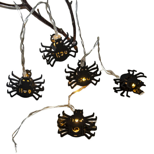 Creative spider LED string lights glowing with a spooky ambiance along an outdoor patio wall.