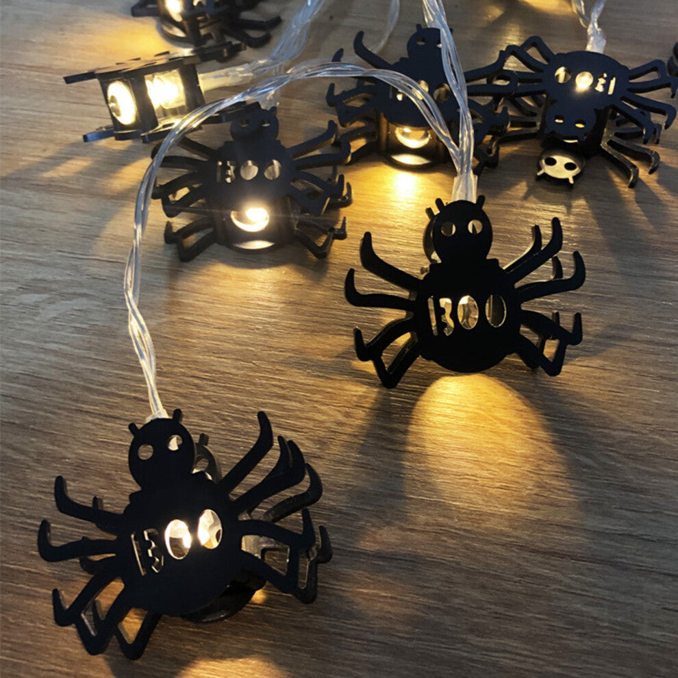 Creative spider LED string lights glowing with a spooky ambiance along an outdoor patio wall.