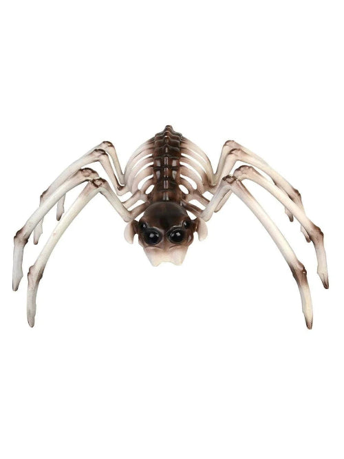 A Smiffys brown and white spider skeleton Halloween prop sitting on a dark wooden table, surrounded by artificial cobwebs under dim atmospheric lighting.
